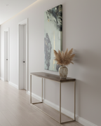 Modern interior with a console table against a wall featuring Freebrd’s “Tugough” abstract wall art