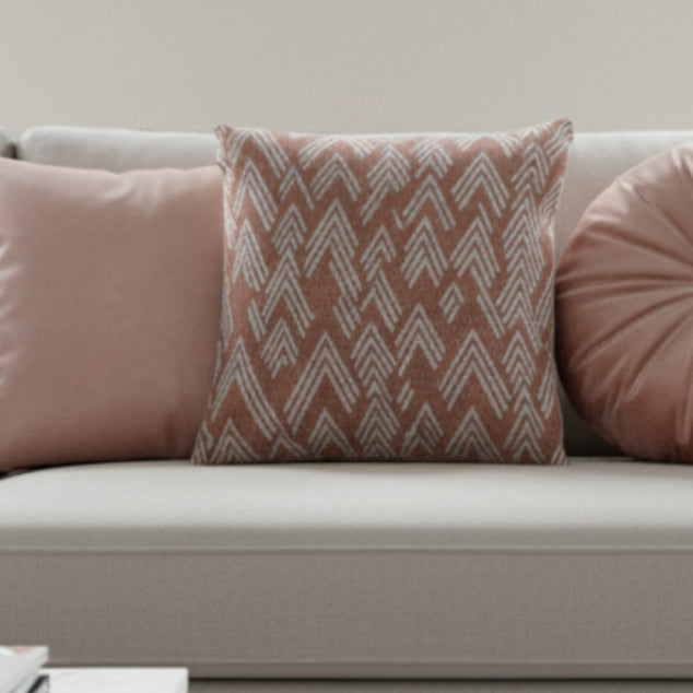 Adore Pink Boho Ikat Patterned Woven Pillow on a light gray sofa.