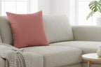 Adore Pink Faux Suede Square Pillow on a beige couch 