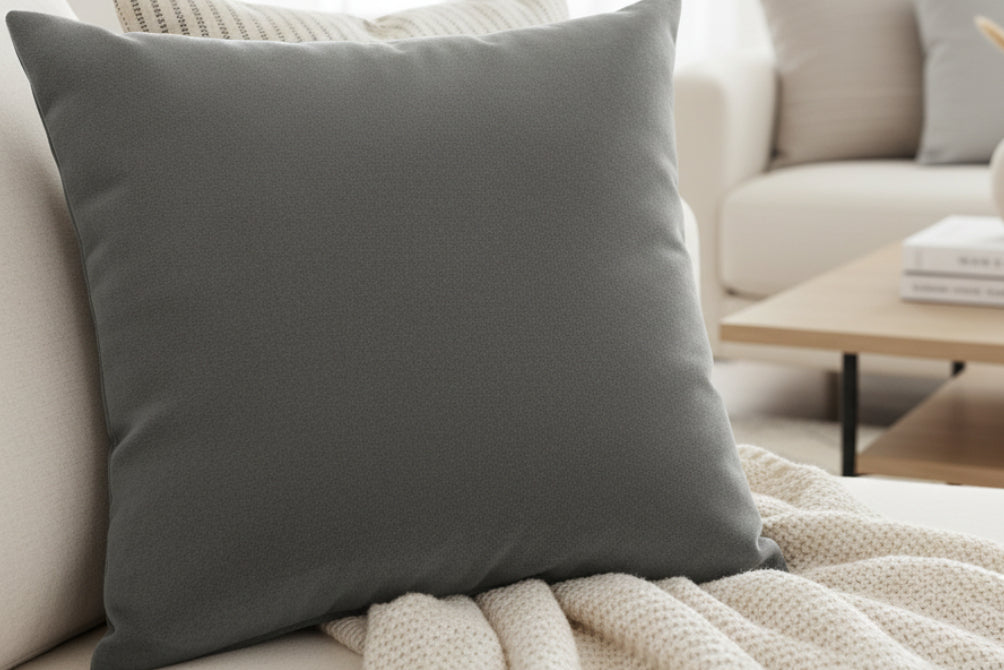 Anchor Grey Faux Suede Luxury Square Pillow on a light gray sofa in a modern living room.