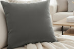 Anchor Grey Faux Suede Luxury Square Pillow on a light gray sofa in a modern living room.