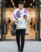 Man wearing a Freebrd Animal Clouds sweatshirt, holding a phone and a black shopping bag