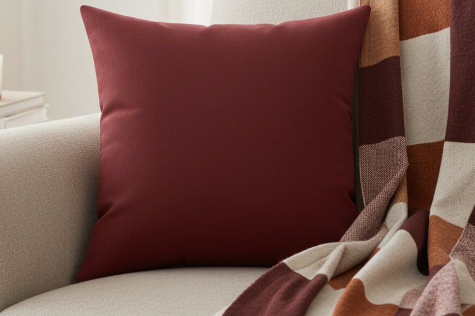 Bloodstone Red luxury Faux Suede Pillow on a beige sofa with a patterned blanket