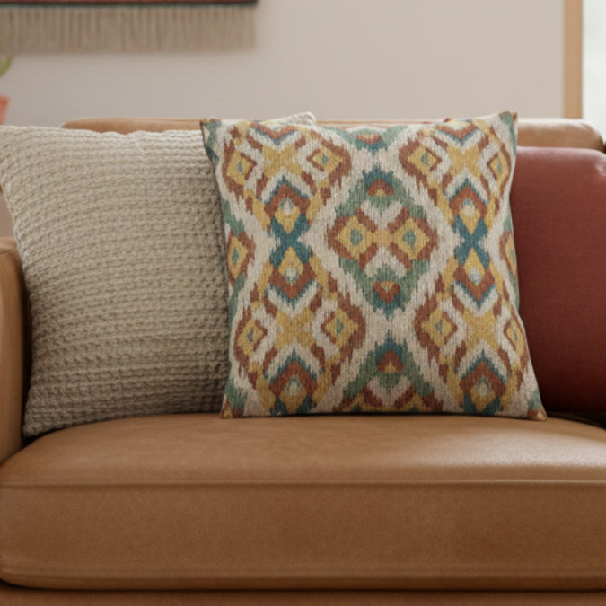 Boho Multicolored Arrow Ikat Woven Pillow on a brown couch