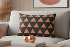 Carbon Fiber Boho Rust Geometric Triangle Lumbar Pillow on a gray sofa in a living room setting.