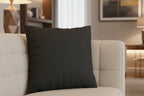 Carbon fiber faux suede pillow on a beige sofa in a living room setting