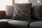 Black sofa with a Carbon Fiber Ikat Modern Boho Woven Pillow  