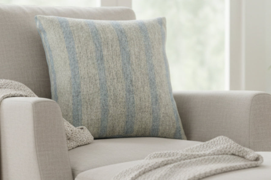 Coastal Danish Blue Off White Woven Stripe Pillow on a lounge chair 