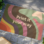 Colorful Abstract Pride "Custom" Welcome Mat with 'Print it your way' text on a stone pavement.