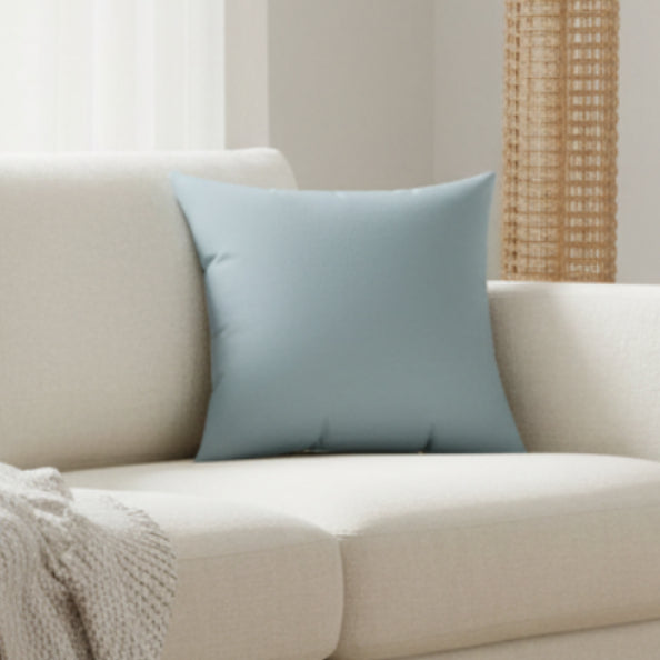 Danish Blue Faux Suede pillow on a beige sofa with a neutral background