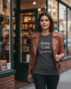Woman wearing a brown leather jacket and a Heather Grey Freebrd designed  t-shirt with 'Human Rights Defender' text