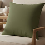 Dark Sage faux suede square pillow in a lounge chair 