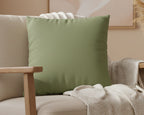 Dark sage Faux Suede Square Pillow on a beige armchair with a neutral background