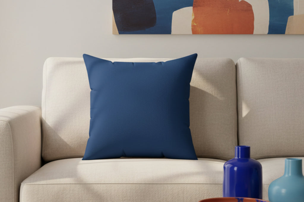 Elegant Blue Faux Suede Square Pillow on a beige sofa with abstract art in the background
