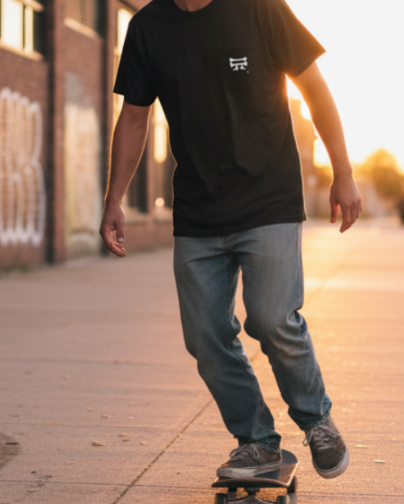 Person skateboarding on a sidewalk with a Classic Cotton Pocket Tee on that has the Freebrd Bone Chikn Logo 