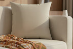 Ivory Grey Faux suede pillow on a beige sofa with a patterned blanket