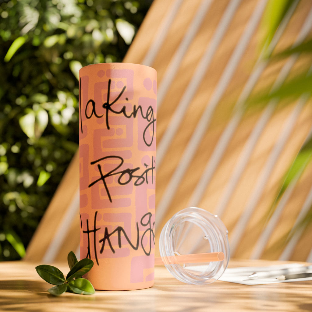 Matte blush tumbler with motivational text on a wooden surface with plants in the background