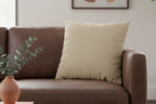 Brown leather sofa with a Natural Jute Luxury Faux Suede Pillow in a living room setting.