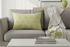 Gray sofa with a Orchid Lime Geometric Triangle Lumbar Pillow and a white coffee table in a living room setting.