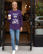 Person wearing a Freebrd designed purple shirt with a positive message, holding a coffee cup, standing in a doorway.