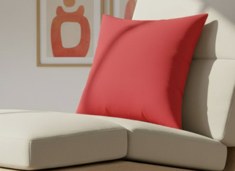 Traditional Red Faux Suede Square Pilloon a beige sofa with a blurred painting in the background
