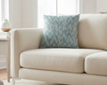 Beige sofa with a Vintage aqua ikat patterned pillow in a bright room. 