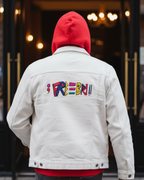 Person wearing a white demin jacket with Freebrd embroidered text on the back, walking into a building entrance.