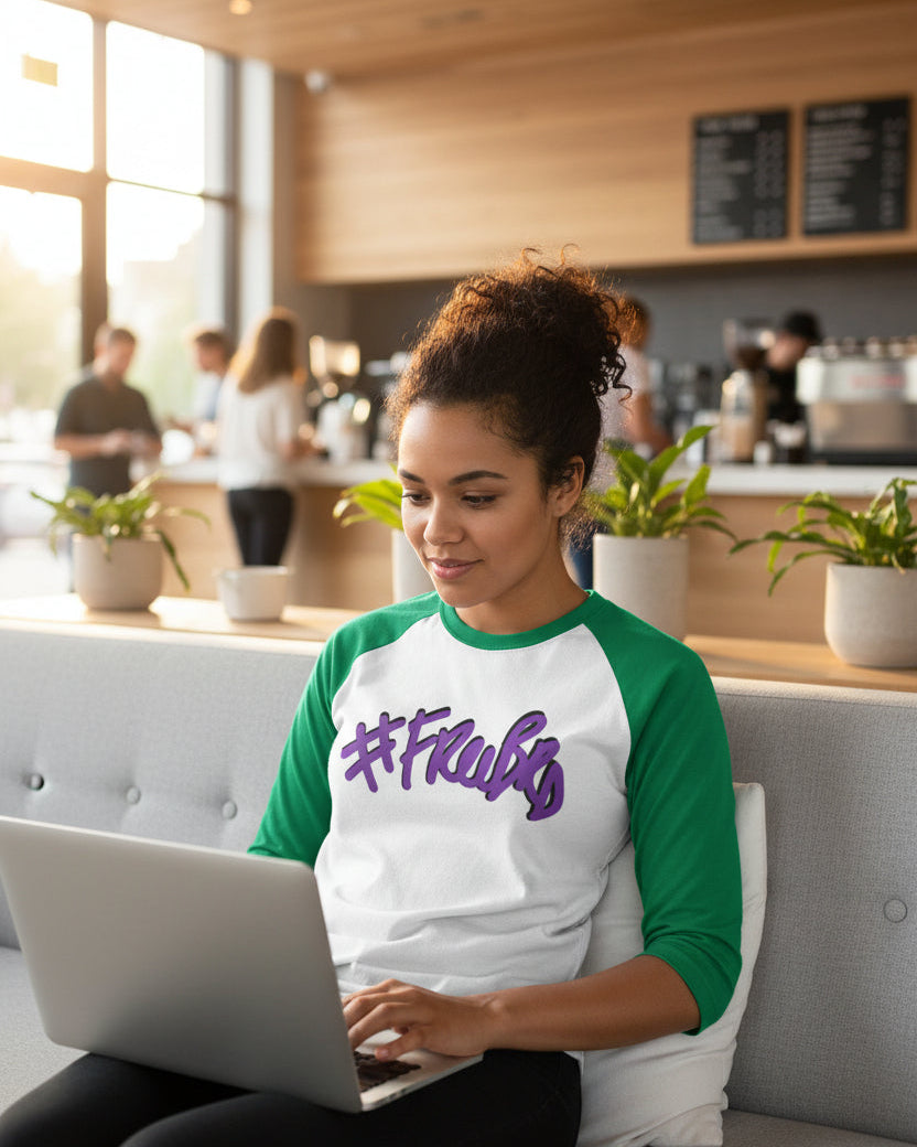Woman using a laptop in a modern cafe setting wearing a Freebrd classic raglan 
