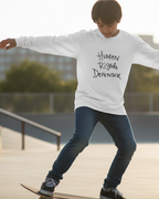 Young person skateboarding at a park wearing a Freebrd designed white long sleeve with 'Human Rights Defender' text