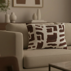 Abstract brown brushstroke lumbar pillow styled on a couch in a modern living room.