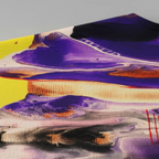 All-over print tee, close-up texture showing polyester fabric weave and abstract art print featuring purple fluid pour, yellow hand motif, red energy strokes, and tribal geometric patterns.