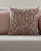 A preview of the Adore Pink Boho Ikat Woven Pillow showing an adore pink background and ivory white chevron ikat styled lines on a couch with other pink accent pillow decor.