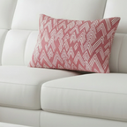 Adore pink ikat lumbar accent pillow styled on a couch in a modern living room.