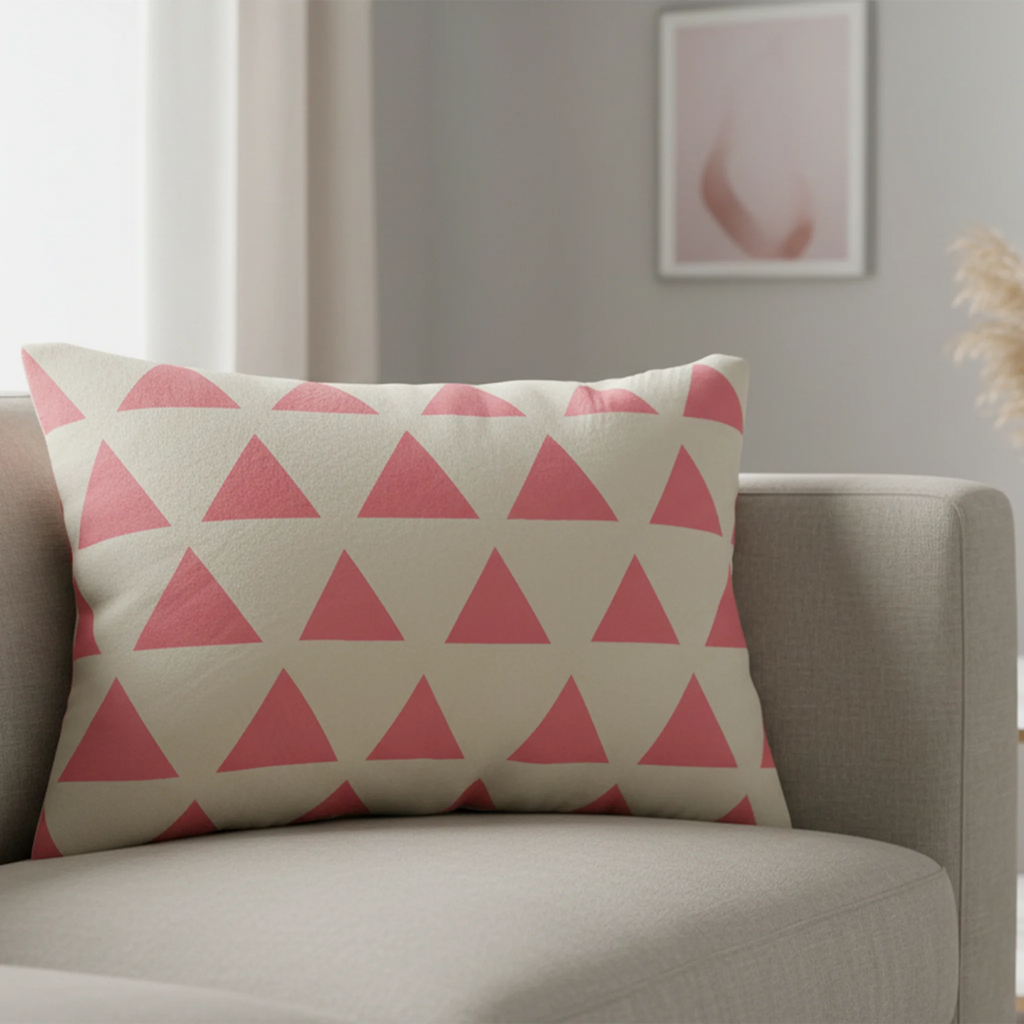 Adore pink triangle pattern lumbar pillow styled on a couch in a modern living room. 