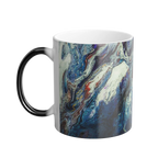 A left side view of the 11 oz abstract coffee cup showing the ‘Afrostar’ acrylic hand-poured canvas artwork design on the left side that displays navy, white, gold, magenta, black and shades of red acrylic paint textures wrapped around the cup, with a black c-shaped handle. 