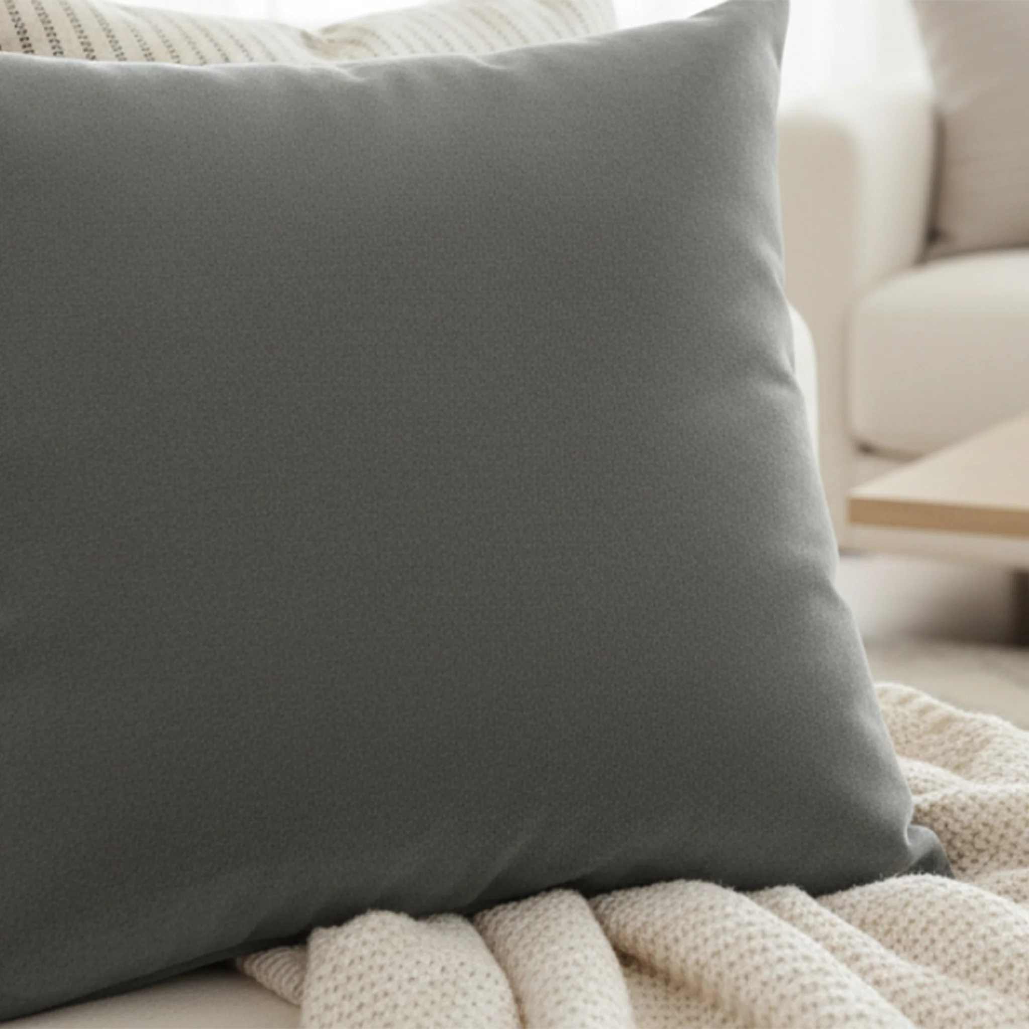 Anchor grey faux suede pillow styled on sofa, dark grey neutral home decor.