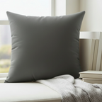 Atomic grey faux suede throw pillow styled in a reading nook, lifestyle view.