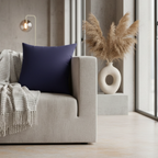 Authentic navy faux suede throw pillow styled on a couch in a soft brutalist living room.