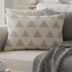 Beige stardust grey geometric triangle lumbar pillow styled on a couch in a modern living room.