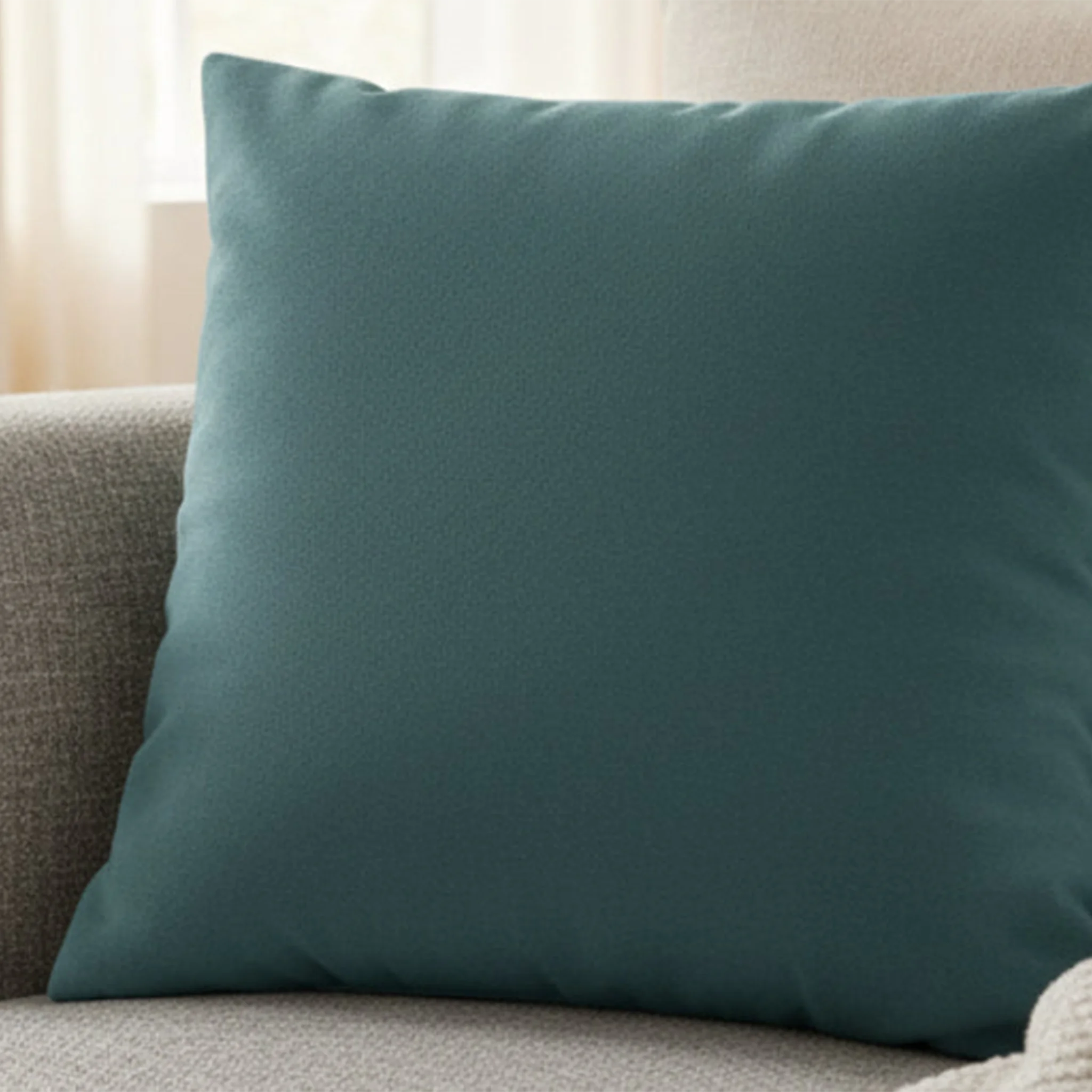 Bismark teal faux suede pillow case styled on a modern sofa couch in a living room.