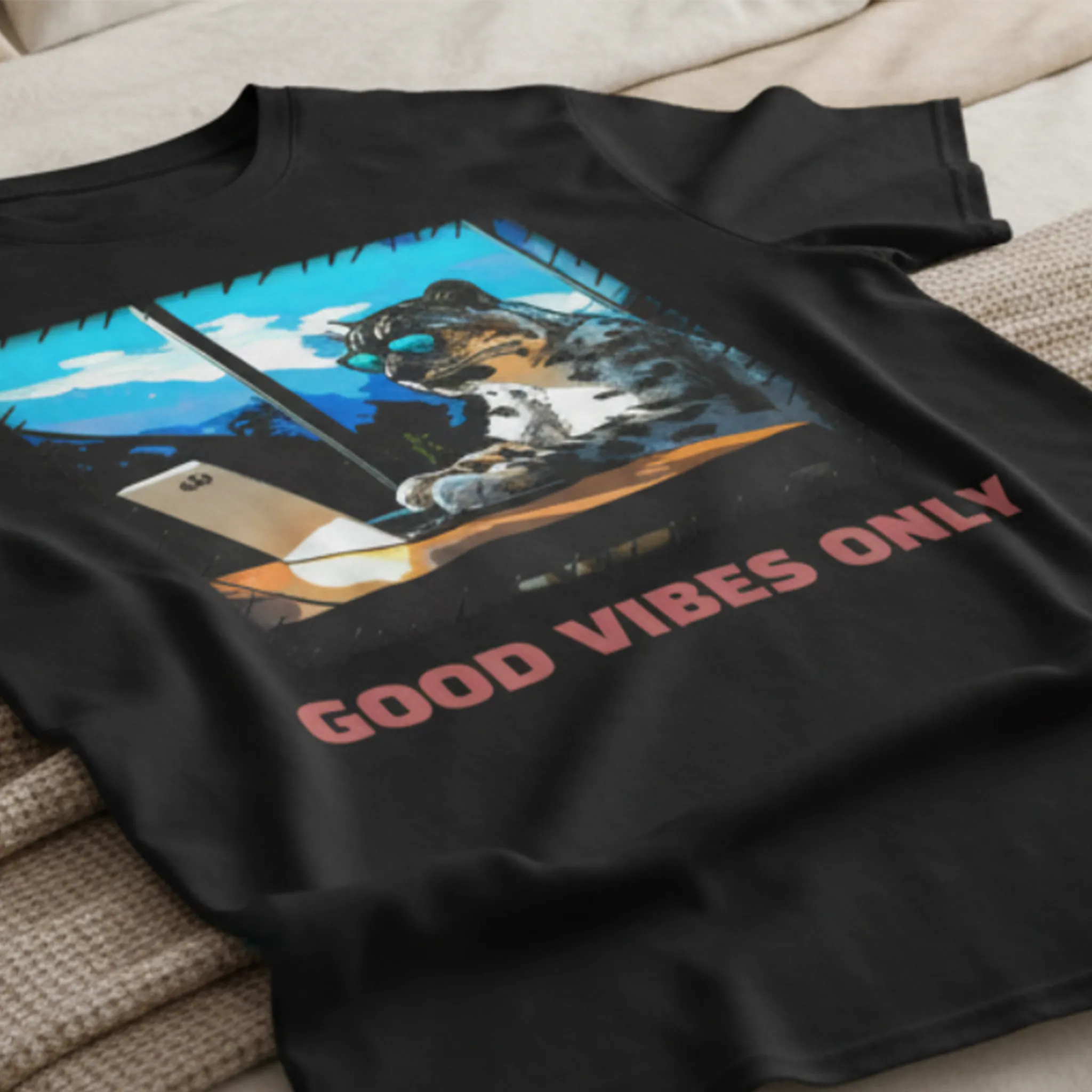 A black Good Vibes Snow Leopard Tee styled on a textured bedding surface background showing the back graphic.