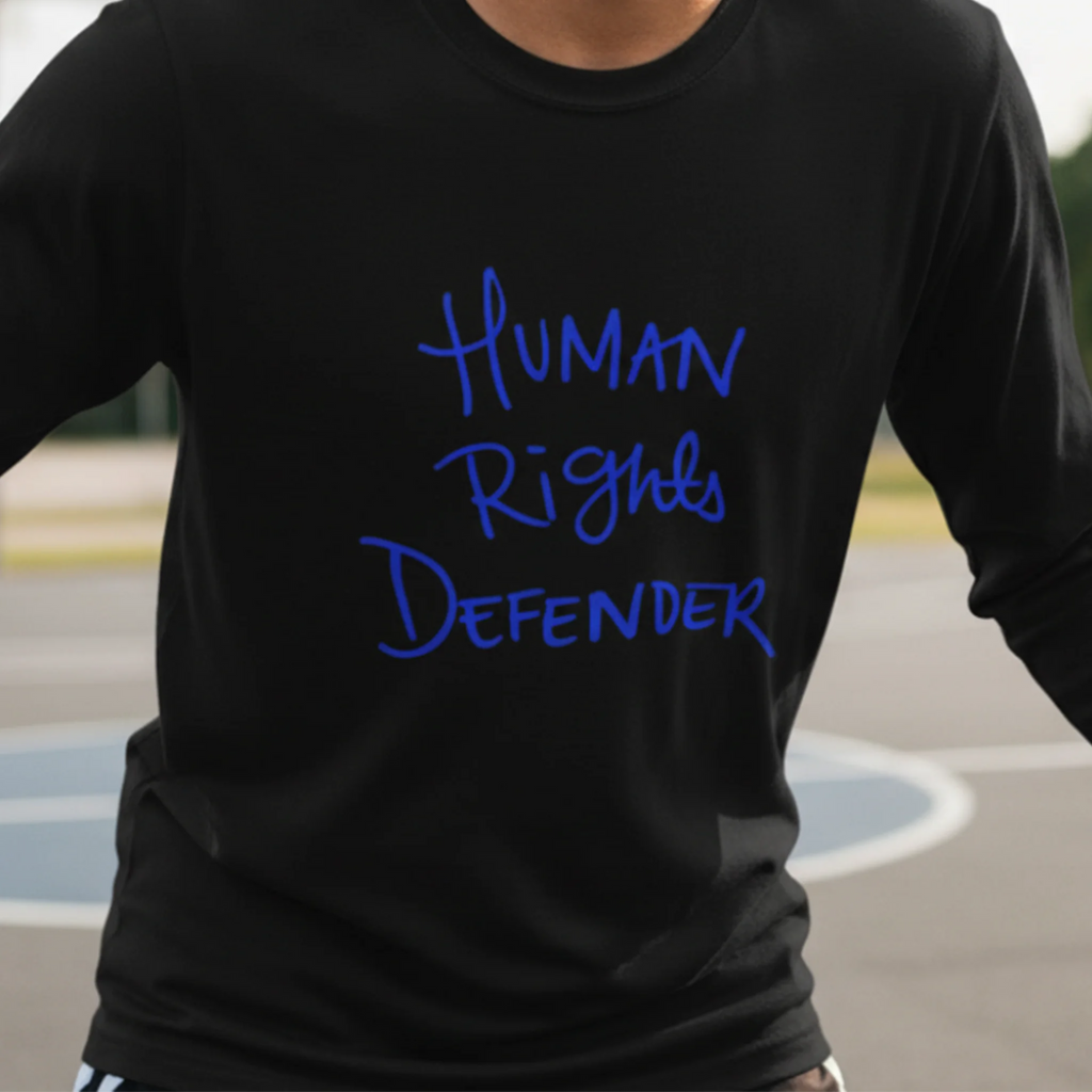 Black Human Rights Defender long sleeve tee, royal blue graphic, outdoor lifestyle front view.