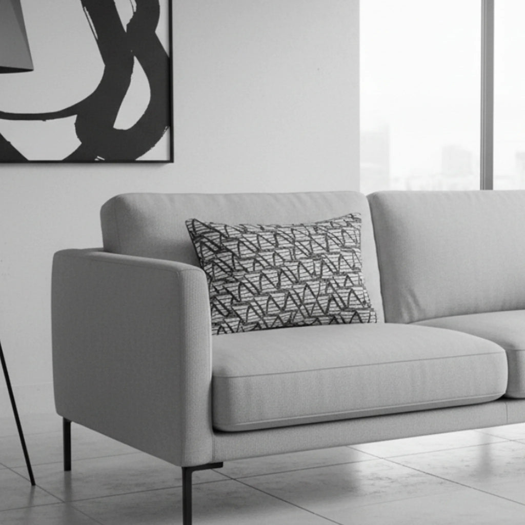 Black white modern geometric abstract lumbar pillow styled on a couch in a modern minimalist living room. 