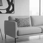 Black white modern geometric abstract lumbar pillow styled on a couch in a modern minimalist living room. 