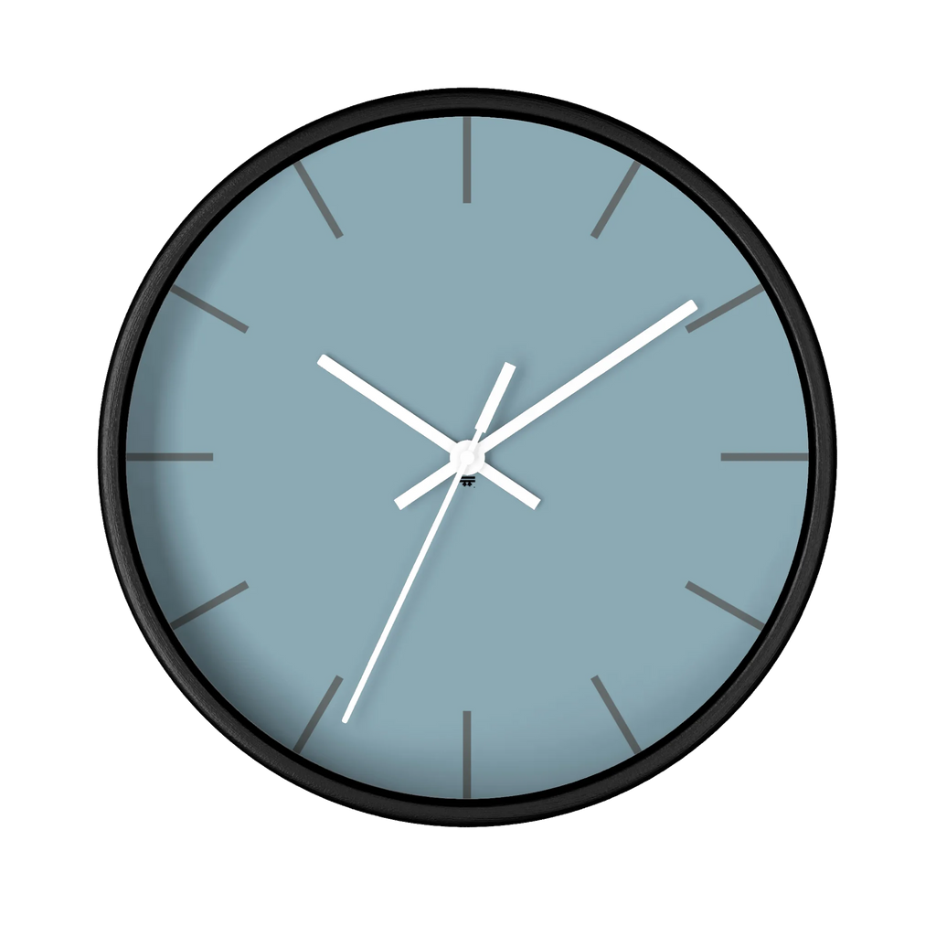 Danish blue minimalist wall clock with black wooden base, white hands, and dark grey markers, front view.