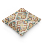 A side view of the Boho Multicolored Arrow Ikat Woven Pillow showing an arrow ikat pattern in a dark terracotta, dark sage, abstract teal and mustard yellow on a beige background. 