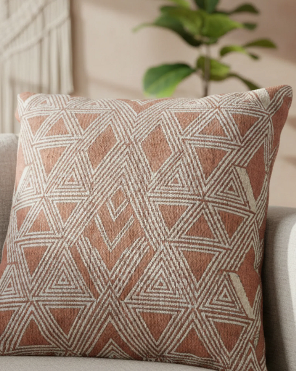 Cream fabric sofa in a warm boho living room with a fiddle leaf fig plant and neutral wall paneling styled with the Salmon Red Boho Woven Pillow.