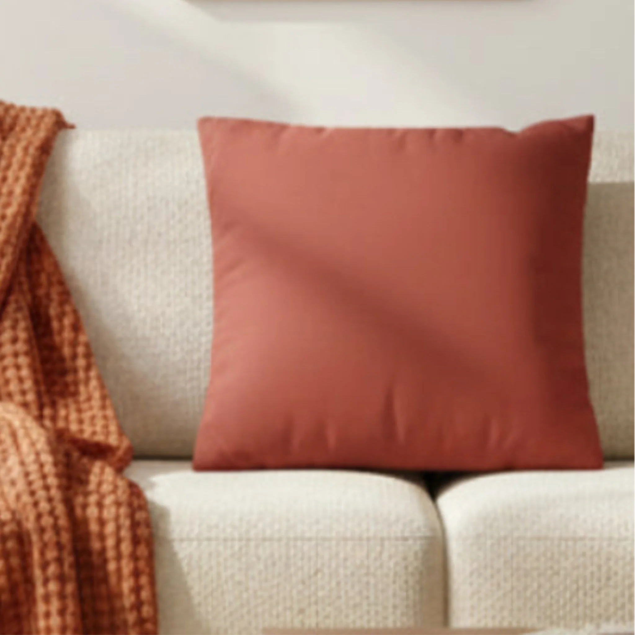 Brownish Red faux suede pillow case styled on a couch in a modern living room.