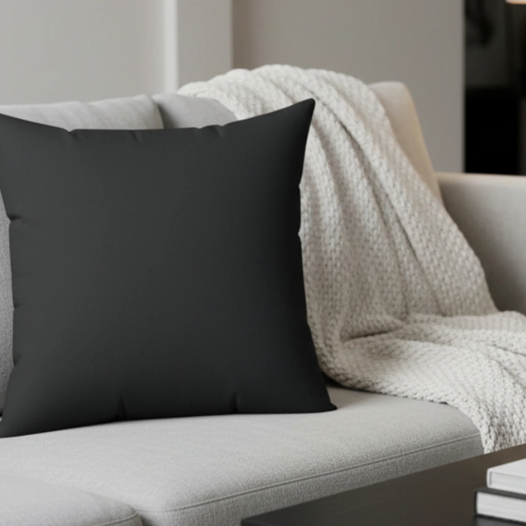 Carbon fiber faux suede pillow styled on sofa, dark charcoal minimalist home decor.