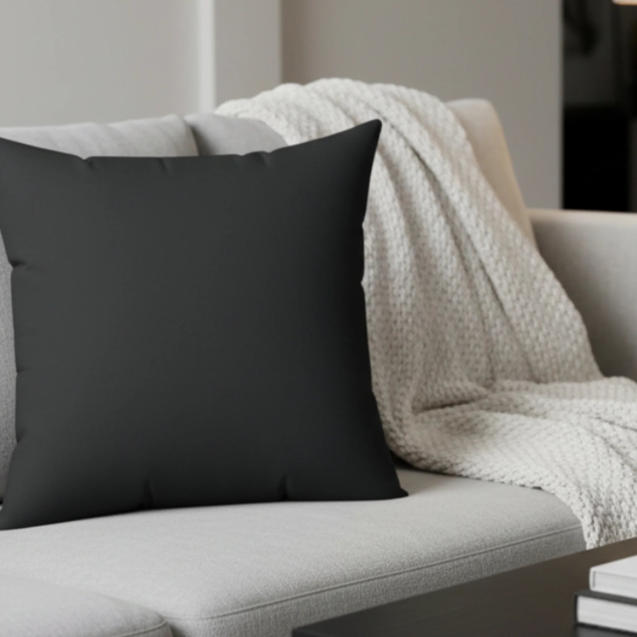 Carbon fiber faux suede pillow styled on sofa, dark charcoal minimalist home decor.